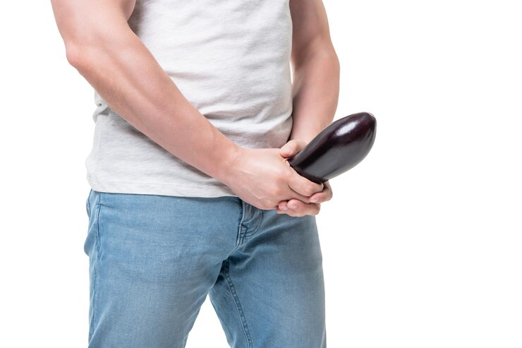 Man gewas weergave met aubergine op kruis niveau imiteren stijve penis geïsoleerd op wit