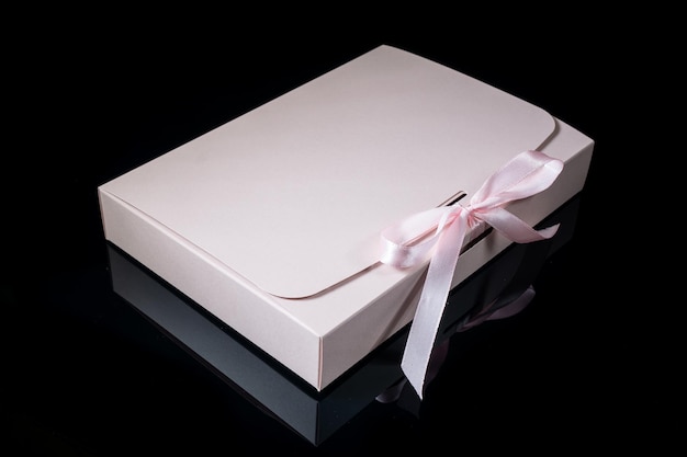 Концепция подарка человека Подарочная коробка с роскошным бантом на темном фоне Горизонтальный с копировальным пространством