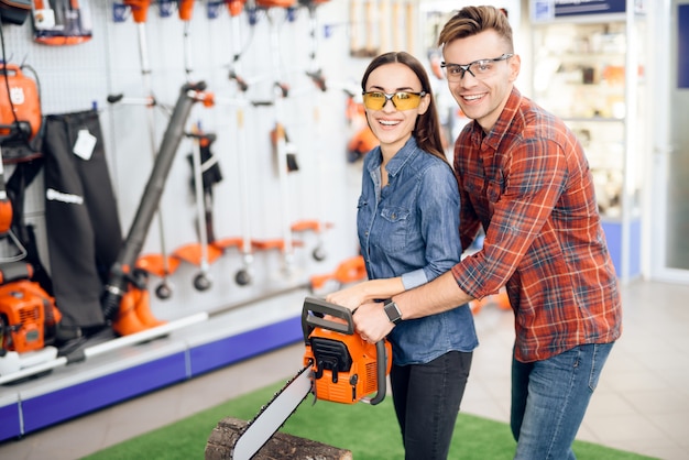 Man and girl holding a chainsaw in hand