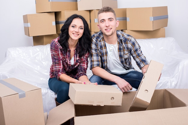 A man and a girl sit at home and take apart the box.