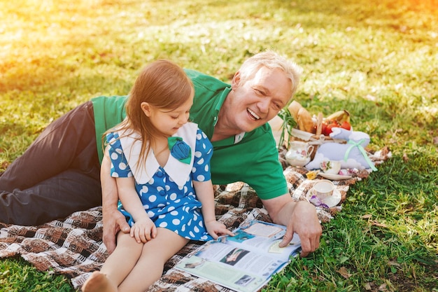 Man and girl with book on plaid