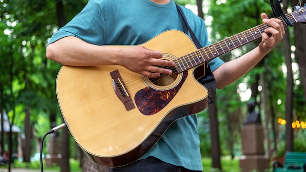 Man gitaarspelen buiten in een park