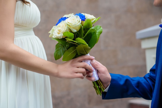 A man gives a bouquet to a pregnant woman