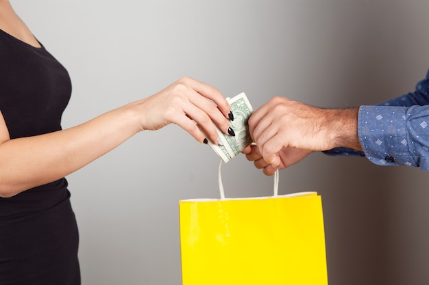 A man gives a gift bag and a woman pays for it. shopping concept