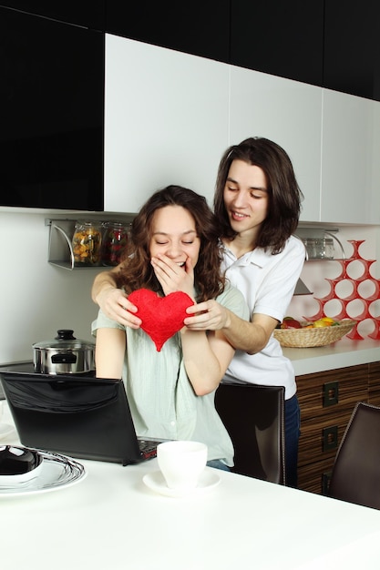 Foto l'uomo dà alla ragazza un cuore rosso