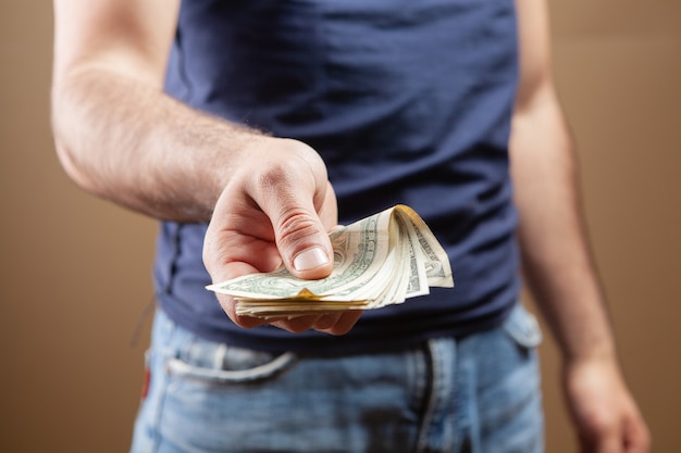 Man gives money on brown background