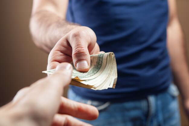 Man gives money on brown background