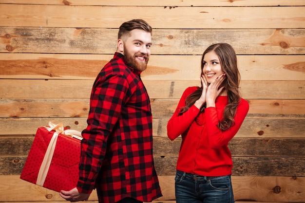 Man gives red gift box to a woman