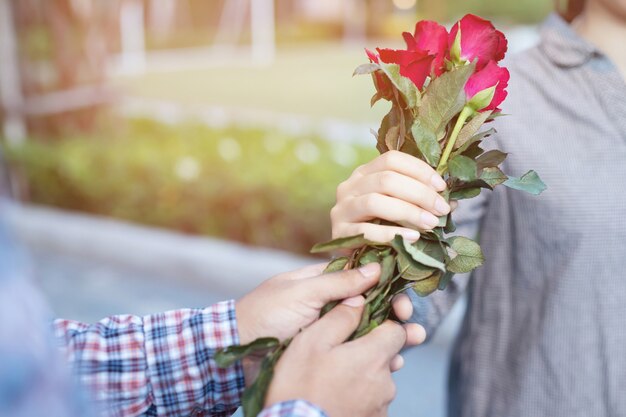 A man gives red roses to his lover on valentines day