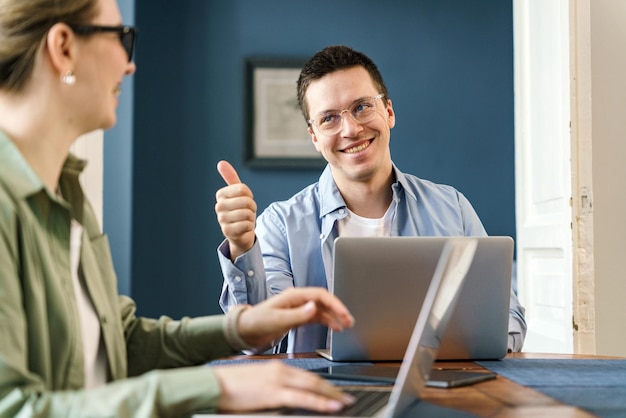 Photo a man gives a thumbsup during a collaborative session with a colleague signifying