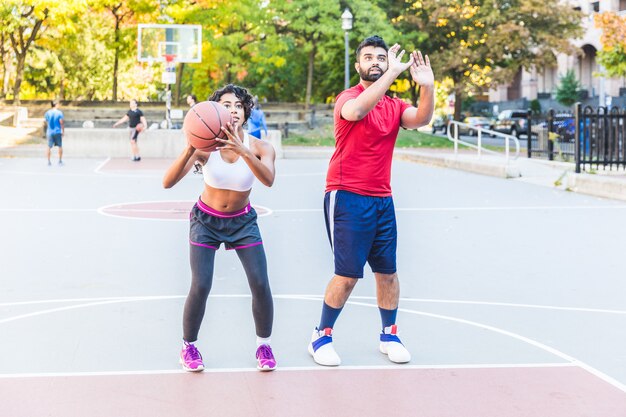 Uomo che dà lezione di basket a una donna