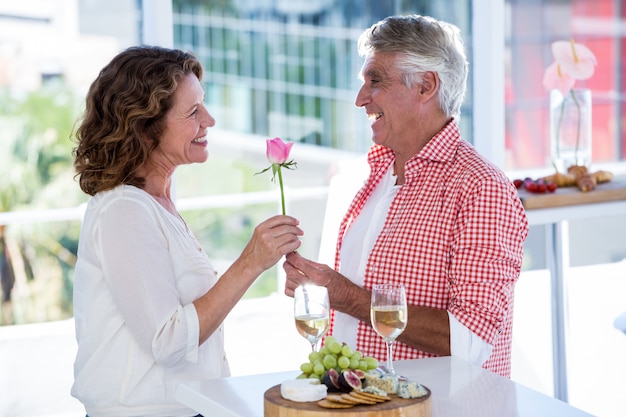 Man giving flower to woman