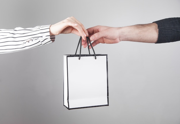 Man giving gift bag to woman.