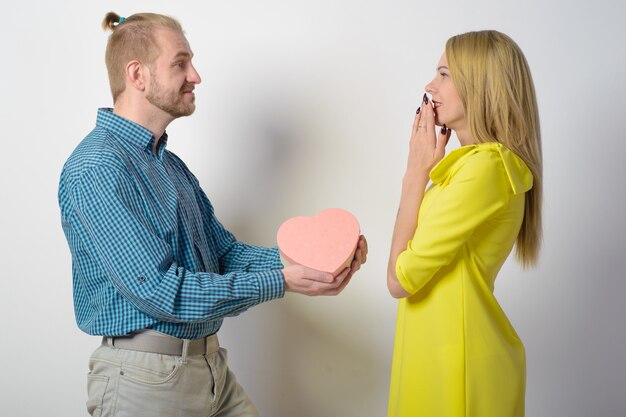 Photo man giving a gift box to a woman