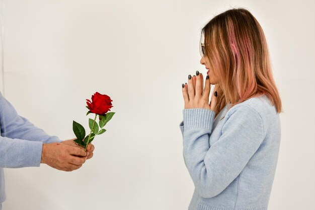 Photo man giving a red rose and surprised woman valentine card concept