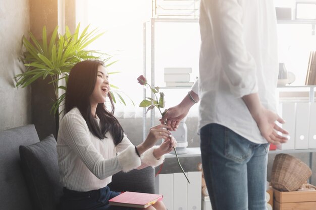 Photo man giving rose to girlfriend at office