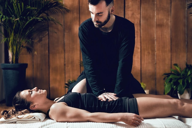 Foto uomo che dà un massaggio shiatsu a una donna alla spa