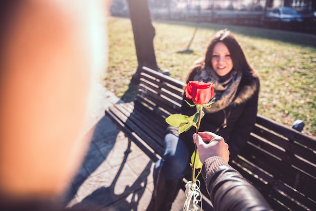 Man giving woman a red rose