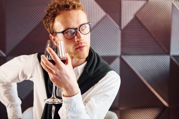 Man in glasses sits by the table Indoors of new modern luxury restaurant