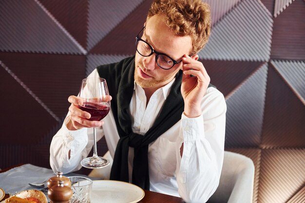 Man in glasses sits by the table Indoors of new modern luxury restaurant