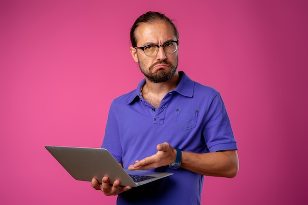 ノートパソコンで立っている眼鏡の男