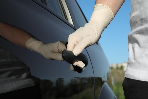 Uomo in guanti che aprono la vista del primo piano della portiera dell'auto