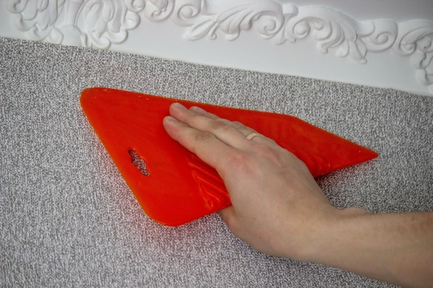A man glues wallpaper repairs the house