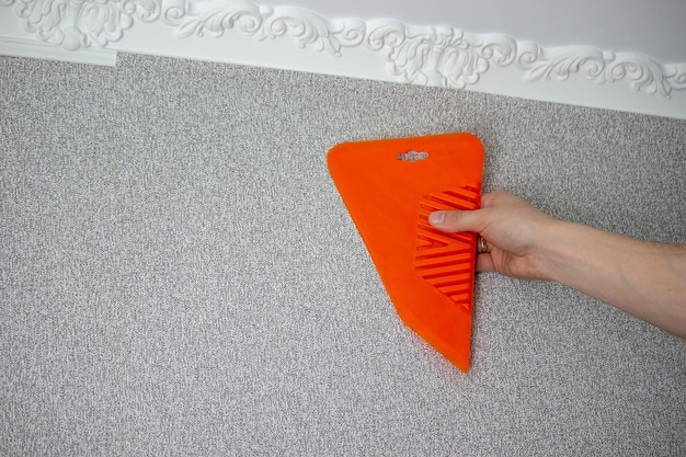 A man glues wallpaper repairs the house