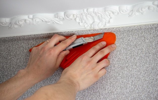 A man glues wallpaper repairs the house