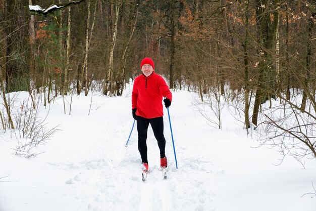 Man goes cross-country skiing in the winter in the forest