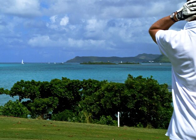 Foto un uomo che gioca a golf davanti al mare