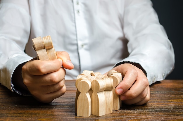 A man grabs a figurine of people from the crowd Hiring employees Market Segmentation