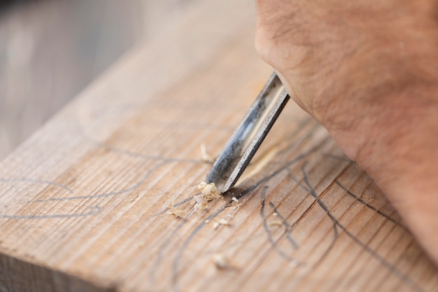 Foto man gravure in hout buitenshuis close-up