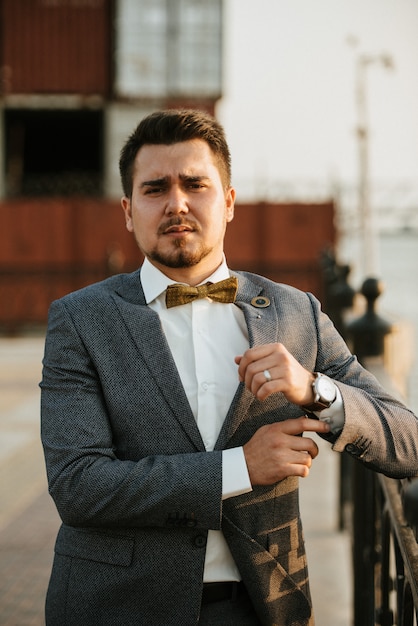 A man in a gray suit poses on the street to advertise men's clothing. Shooting for men's clothing store