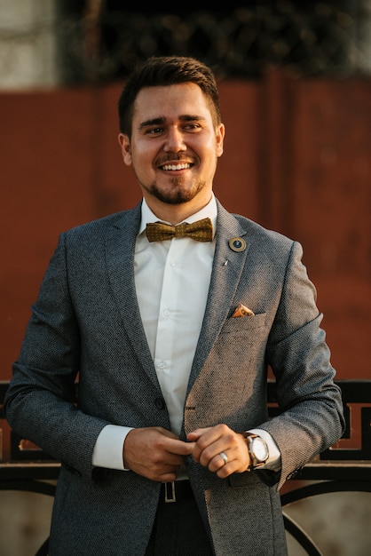 A man in a gray suit poses on the street to advertise men's clothing. Shooting for men's clothing store