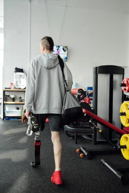 Man in Gray Sweater and Black Shorts Holding Water Bottle ang Gym Bag Stock Photo