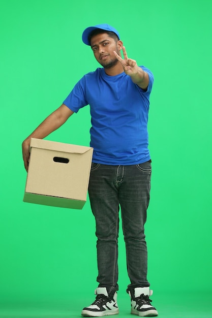 Photo a man on a green background with box show a victory sign