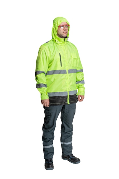 A man in green special clothes for workers in a helmet on a white isolated background