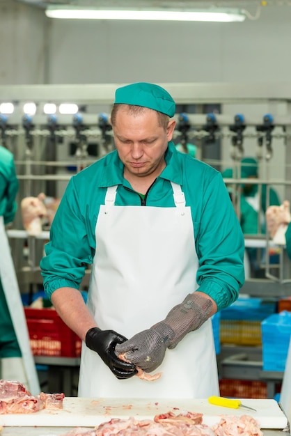 A man in a green uniform stands in front of a machine that says'meat '