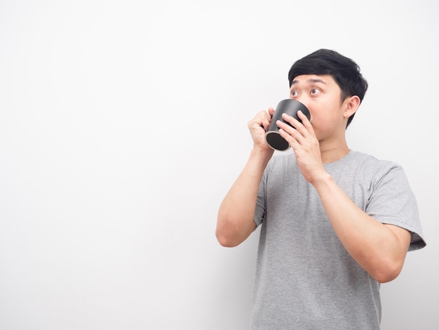 Man grey shirt drinking coffee and looking at copy space