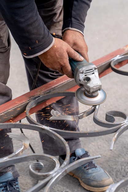 Man grinds metal with angle grinder in metal workshop Vertical frame