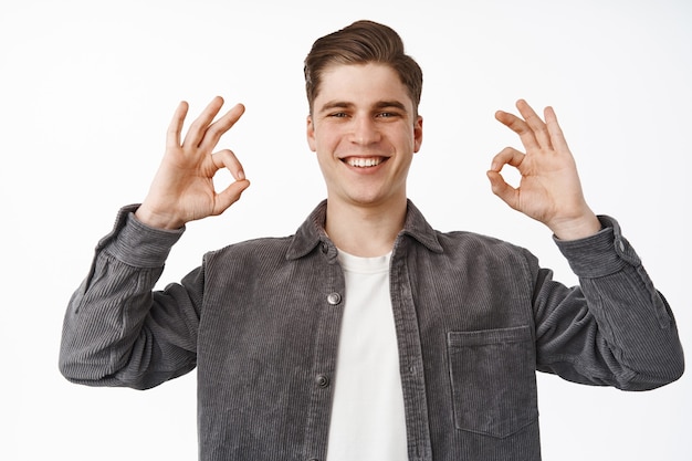 Amico, ragazzo mostra denti bianchi, ok segno zero, ok d'accordo e loda qualcosa di buono, mi piace e approva il bianco