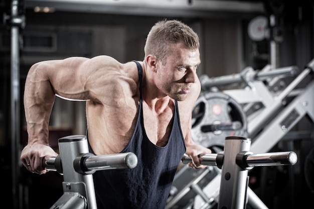 Man in gym at dip exercise