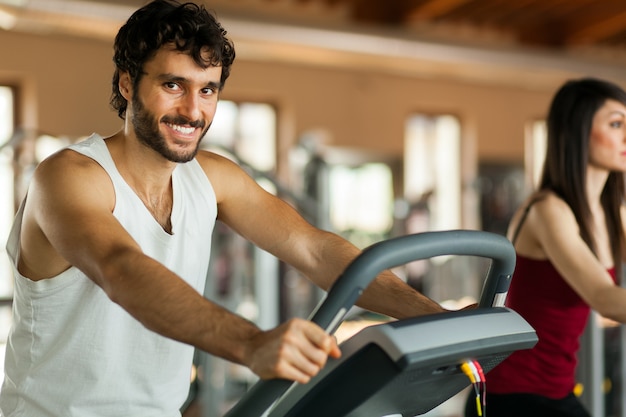 Man in the gym, exercising his legs doing cardio training on bicycle