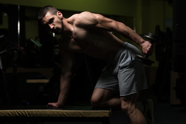 Man In The Gym Exercising Triceps With Dumbbell