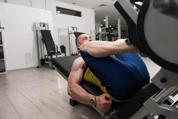 Man In Gym On Machine Exercising