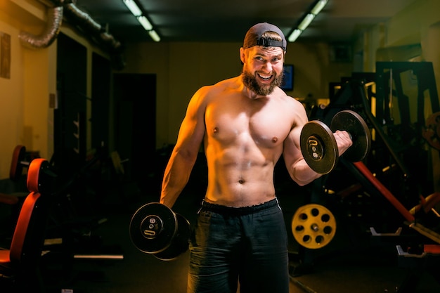 Man in gym training with dumbbells