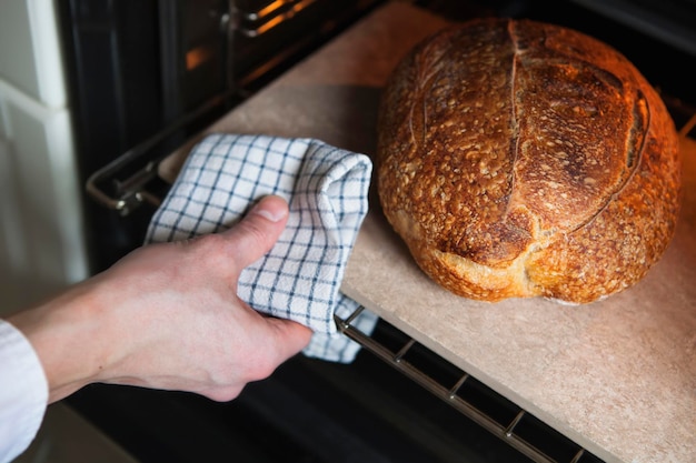 Man haalt zelfgebakken warm brood uit de oven