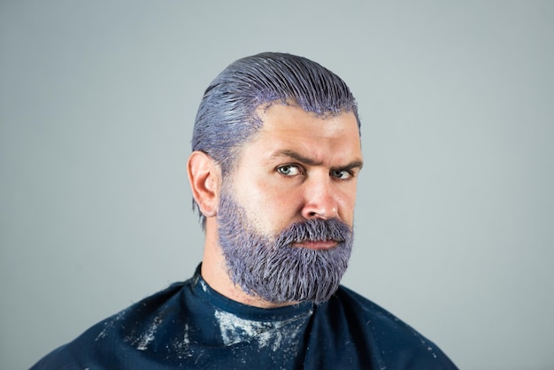 Colorazione dei capelli dell'uomo. ragazzo hipster barbuto. processo di un uomo che ha il colore dei capelli al salone di parrucchiere.