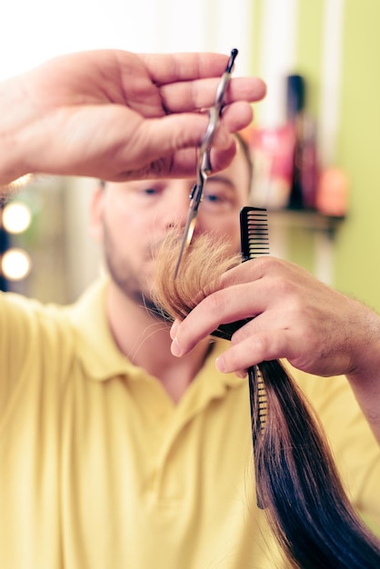 Man hairdresser cutting the hair of a woman.